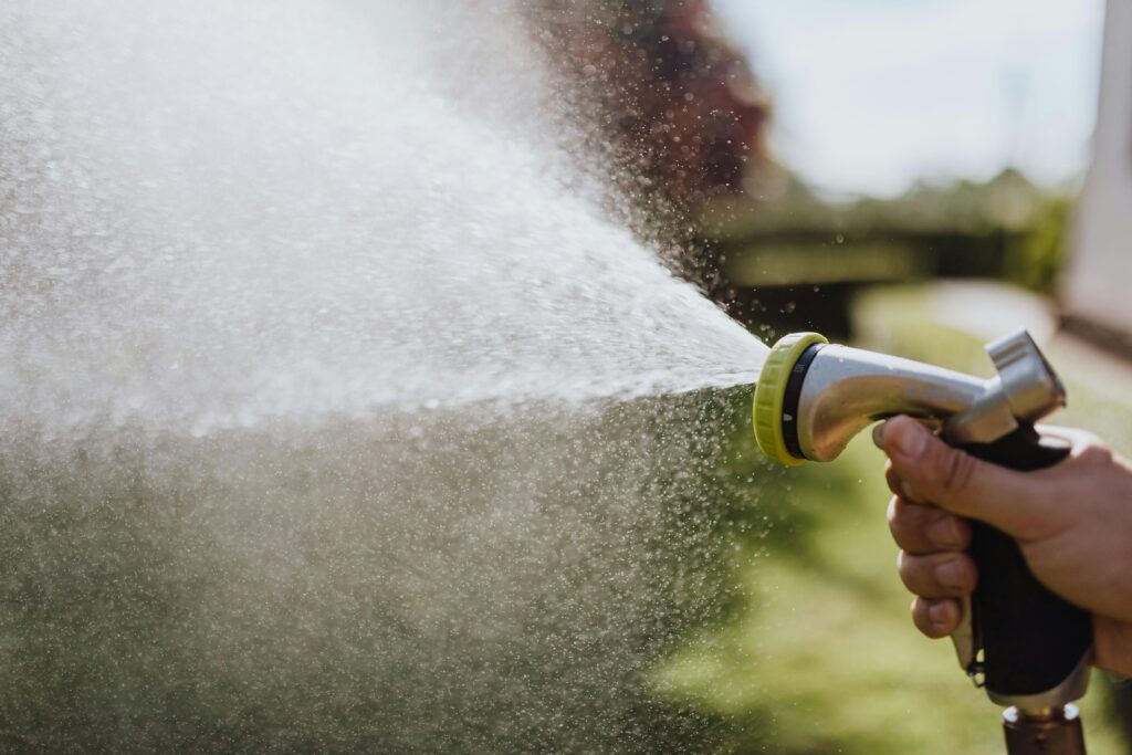 Close-Up Photo of a Person Using a Spray Hose