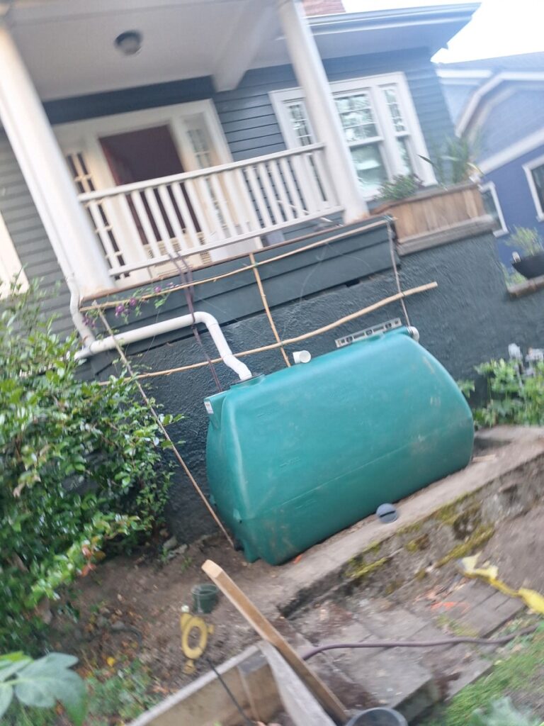 Recently completed rainwater harvesting system installation in Seattle featuring advanced hydraulic collection, sustainable water storage, and a custom plastic water tank for efficient residential water management